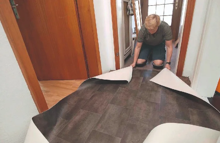 Person verlegt Vinylboden im Flur